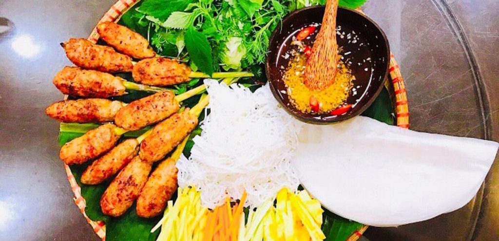 Mẹt nem nướng cuốn bánh tráng gồm nem nướng vàng ruộm, bún tươi, rau sống, xoài xanh, dưa leo, khóm thái sợi, bánh tráng và chén nước chấm chua ngọt hấp dẫn.