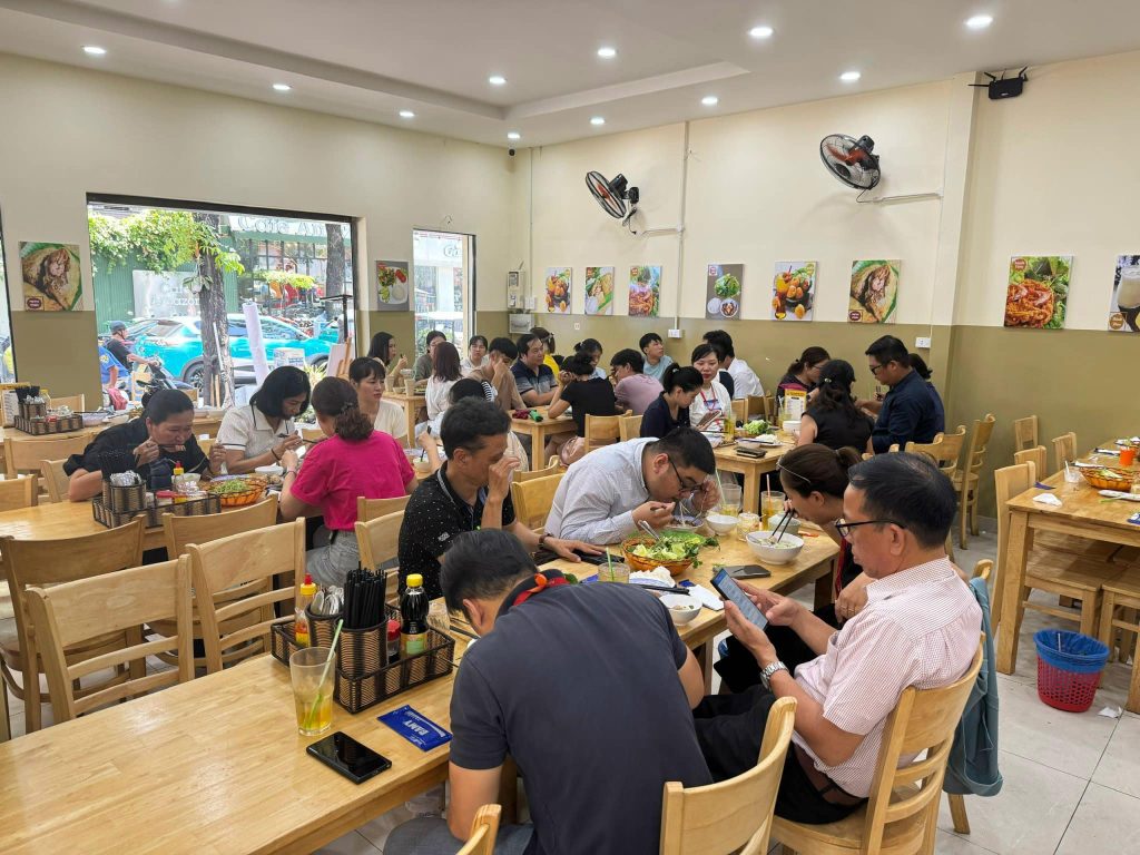Không gian bên trong quán ăn tại Sài Gòn đông khách, thực khách tấp nập, thưởng thức bún chả và các món ăn Bắc Bộ trong không khí ấm cúng.